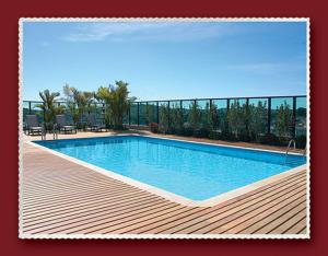 a large swimming pool on a deck with at Master Plaza Hotel in Barbacena