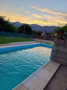 a swimming pool with blue water in a backyard at Complejo Huayra Huasi in Villa Bustos