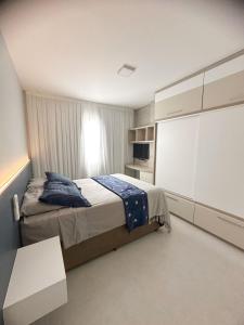 Un dormitorio con una cama y un televisor. en Turim, en Balneário Camboriú 15 fotos más