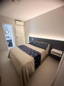 Un dormitorio con una cama con almohadas azules. en Turim, en Balneário Camboriú