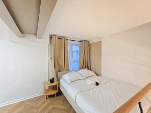 a small bedroom with a bed and a window at La Suite Brazier in Lyon
