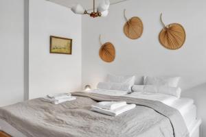 une chambre blanche avec un lit avec deux serviettes dessus dans l'établissement Design District w Free Parking Garage, Balcony, Netflix, 200m tram&bus, à Helsinki