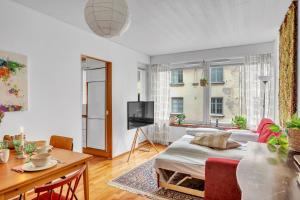 un salon avec un lit et une table dans l'établissement Design District w Free Parking Garage, Balcony, Netflix, 200m tram&bus, à Helsinki