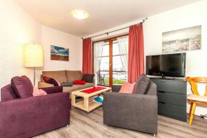 a living room with two couches and a flat screen tv at Ferienwohnung Rosendahl in Reit im Winkl