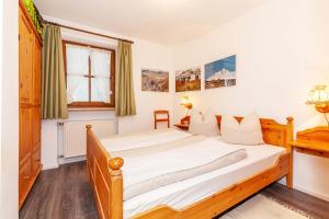 a bedroom with a bed and a desk at Ferienwohnung Rosendahl in Reit im Winkl