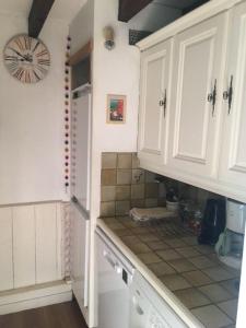 Una cocina con gabinetes blancos y encimera. en Apartment du Pic de l 'Ours, en Théoule-sur-Mer 3 fotos más
