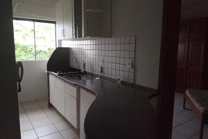 a kitchen with a black counter top and a sink at AP 03 DO CANTINHO DO SOSSEGO in Dourados