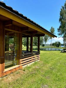 a wooden cabin in a field of grass at Kempings Paegļi in Kaijciems