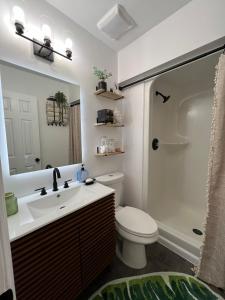 a bathroom with a sink and a toilet and a mirror at Lovely 2BR Condo near UNCW Beach in Wilmington
