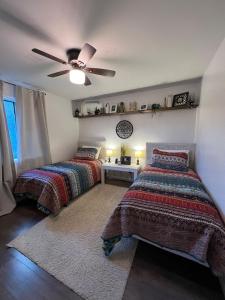 a bedroom with two beds and a ceiling fan at Lovely 2BR Condo near UNCW Beach in Wilmington +30 photos