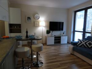 Una cocina y una sala de estar con una mesa y un sofá. en Apartament Przy Plaży, en Krynica Morska