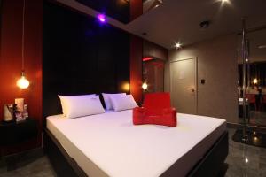 a bedroom with a white bed with a red bag on it at Misk Motel in Anhumas