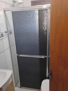 a shower with a glass door in a bathroom at Alugo casa para Argentinos, espaço inteiro in São Gabriel
