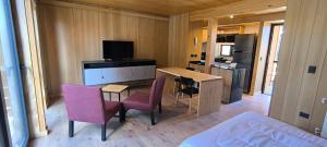 ein Wohnzimmer mit Tisch und Stühlen und eine Küche in der Unterkunft alquiler temporario en villa la angostura in Villa La Angostura + 3 Fotos