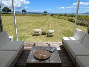 a living room with a couch and a table and chairs at Epic Beachfront Bure - Taipa in Taipa
