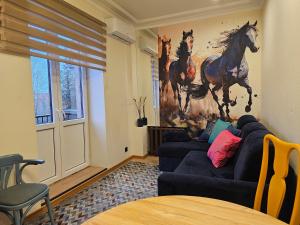 雷泽克内Luxury Stable 1的客厅配有沙发和马画