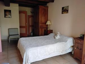 una camera da letto con un letto con un orsacchiotto sopra di Maison familiale a Médis