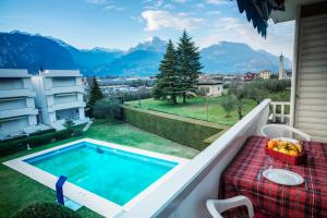 a swimming pool on a balcony with a table at Casa Bianca in Riva del Garda +2 photos