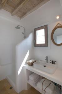 un bagno bianco con lavandino e specchio di CasaDei Pool 4-BDR Sea View Villas 'Anemos' & 'Petra' with Nighttime Security Guard a Panormos - Mykonos Altre 42 foto