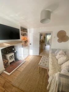 a living room with a couch and a fireplace at Charming One Bed Cottage in Historic Market Town in Romsey +23 photos