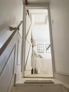 a stairway with a door leading to a bedroom at Charming One Bed Cottage in Historic Market Town in Romsey