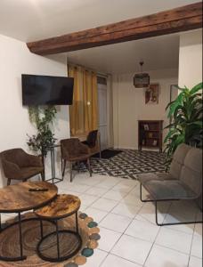 a living room with furniture and a flat screen tv at Gîtes Le Meslaysien in Meslay-du-Maine