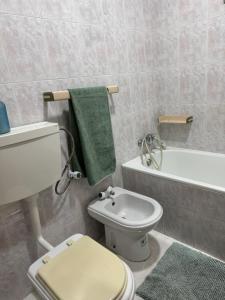 a bathroom with a white toilet and a bath tub at Descanso imparcial in Prazeres