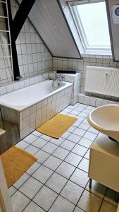 a bathroom with a bath tub and a window at 80qm Monteuroase in Melsungen - Schwarzenberg MwSt ausweisbar in Melsungen +5 photos