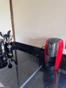 a red and black coffee maker sitting on a counter at Chalé Choupana - Capim Cidreira in São Bento do Sapucaí