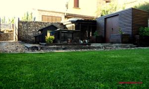 un patio con un edificio y un césped verde en Casa Rural Las Lezas, en Biel