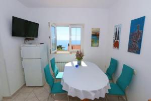 a dining room with a table and chairs and a television at Apartments Vacation Jakisnica in Jakišnica