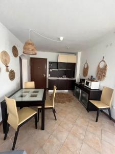a kitchen and dining room with a table and chairs at Oasis Resort Apartments in Lozenets