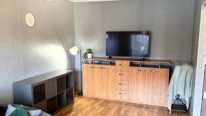 soggiorno con TV a schermo piatto e mobile in legno di Quiet and comfortable apartment with parking for a nice stay for two, one or a couple guests with a child a Tallinn