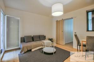 una sala de estar con un sofá y una mesa en Bel appartement avec terrasse, en Clichy