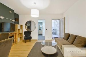 una sala de estar con un sofá y una mesa en Bel appartement avec terrasse, en Clichy