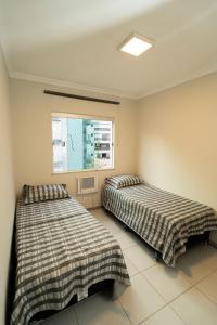 deux lits côte à côte dans une pièce dans l'établissement Apartamento 100m Praia do Forte, à Cabo Frio 55 autres photos