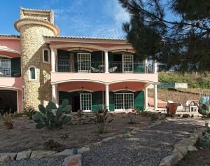 a large pink house with a tower on top of it at Casa Picamilho in Porto de Mós