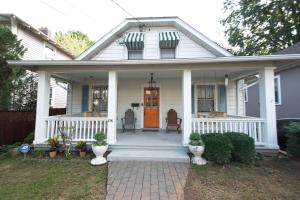 une maison blanche avec une terrasse couverte à l'avant et une porte orange. dans l'établissement The Navel Nalle - Downtown Bungalow, Patio, Parking, à Charlottesville
