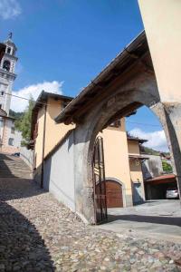 a building with a gate and a building with a clock tower at The clock house -Centro storico- in Clusone
