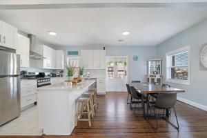 a kitchen with white cabinets and a table and chairs at 4BR 2BA Luxe Beach Estate II in Atlantic City