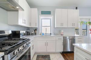 a kitchen with white cabinets and a stove top oven at 4BR 2BA Luxe Beach Estate II in Atlantic City