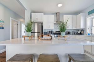 a kitchen with a large white counter with two stools at 4BR 2BA Luxe Beach Estate II in Atlantic City