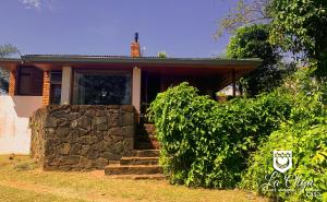 a house with a stone wall and stairs in front of it at Casa LA OLGA in Eldorado