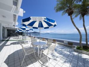 a patio with chairs and an umbrella and the ocean at Ibusuki Kaijo Hotel - Vacation STAY 87383v in Ibusuki +29 photos