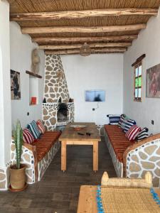 ein Wohnzimmer mit Sofas, einem Tisch und einem Steinkamin in der Unterkunft Octopus house in Wassane