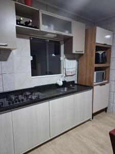 a kitchen with a sink and a stove in it at Habitación Familiar in Pântano Grande