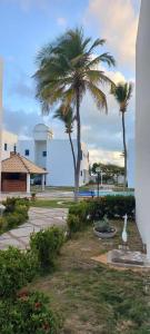a palm tree and a white bird in a park at Porto Canoa Apartamento in Aracati +8 photos