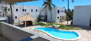 a swimming pool in front of a building at Porto Canoa Apartamento in Aracati