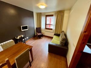 ein Wohnzimmer mit einem Tisch und ein Esszimmer in der Unterkunft Lotila Flats Cuirgu in Felechosa + 13 Fotos