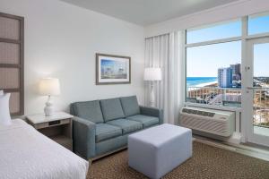 a hotel room with a bed and a couch and a window at Best Western Premier - The Tides in Orange Beach +50 photos